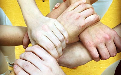 Teamwork - Hände der Teammitglieder überkreuzt